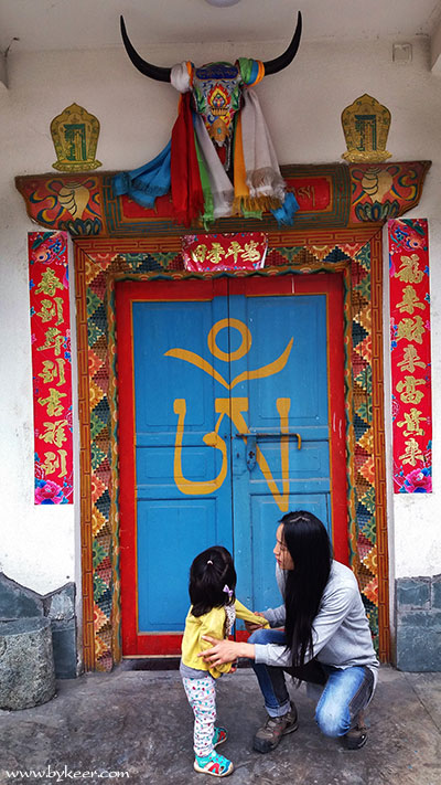 夹金山穿巴朗山(6): 藏族的门楣，都是实木雕花而成；而春联却又是典型的汉族传统？<br>大门上这个字是什么含义，有谁知道吗？