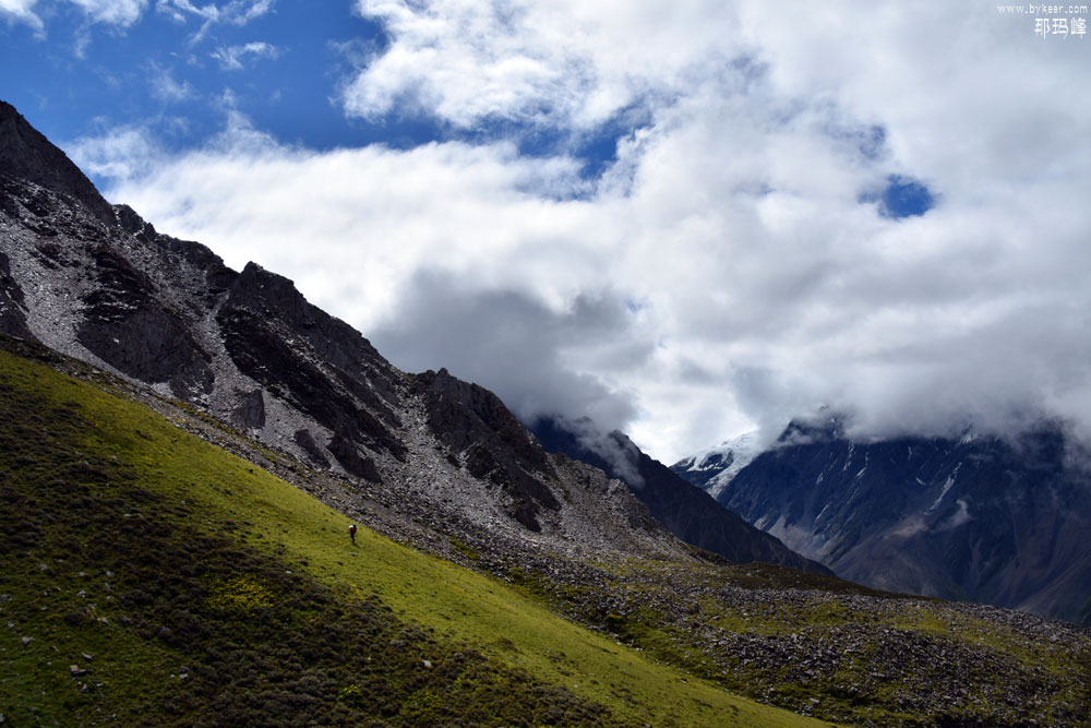 贡嘎卫峰之那玛(19): 阳光射出云层，照亮山脊，这是攀爬在山沟另一侧的同伴
