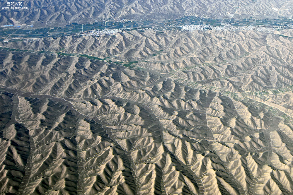 西北以北・兰州(10): 随着飞机的下降，大地又显现出另一种景观：<br>所有沙丘的沟壑罅隙，全都筑成连缀的小块田地，却又与沙地一般干涸，寸草不生。<br>也不知是用于固沙的，还是农田？