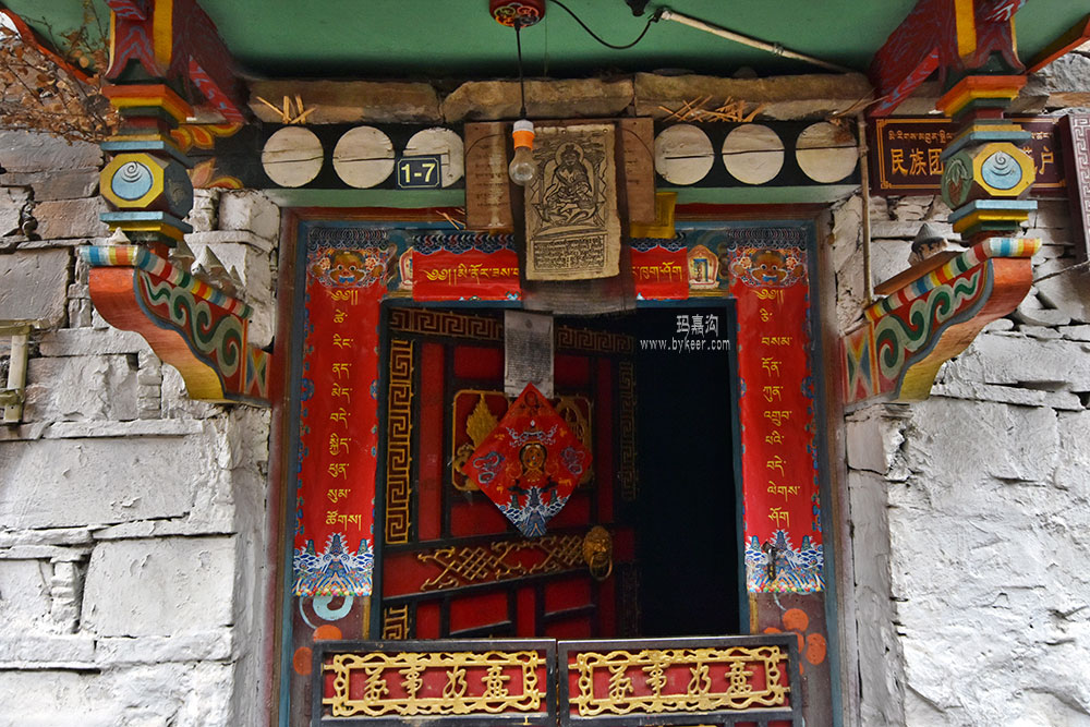 独走玛嘉沟(4): 小巷中的藏家门口。<br>写着藏语的春联，门楣上驱鬼的神符，到底是藏汉融合的文化，还是藏族自有的风俗，不懂也不敢乱说。