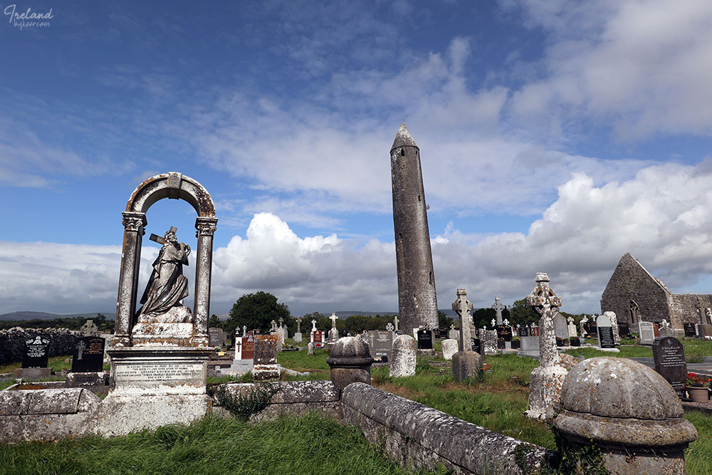 The Emerald Isle 爱尔兰(一)(24): 乡野路边的一处圆形古塔（round tower）和墓地。<br>和所有见过的欧美墓地一样，绿野、蓝天、阳光灿烂；石质十字架、墓碑和残垣断壁，映衬出一种别样审美。