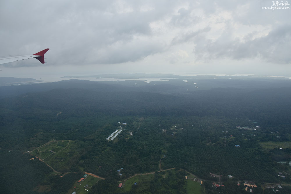 婆罗洲的雨林(二)(22): 这张照片，是从吉隆坡飞山打根快降落时拍的。这里居然能看到我们旅居的庄园和周遭的乡野。<br>看吧！这片全球最高的热带巨树森林之一，天空之眼中，就只是夹在油棕榈园和海湾间的一脉浅浅的山脊，<br>无数生灵栖居于此，Kabili Trail横贯其间，我越野跑中那么渴望一窥其中的神秘之地，只是这片海岛上的小小一隅……<br><br><br><br><br><br><span style='font-weight:bolder;font-size:26pt'>:::: Sandakan 山打根 ::::</span><br><br>
